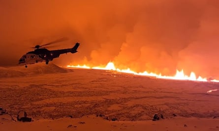 A handout photo from the Icelandic Coast Guard shows a coastguard helicopter flying over the volcano.