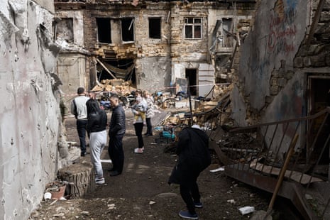 People gather in a yard where a Russian drone hit on Tuesday, in Odesa, injuring at least nine people.