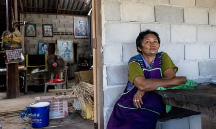Supa Taengthong sits outside her home, the walls of which have been knocked down by wild elephants on numerous occasions