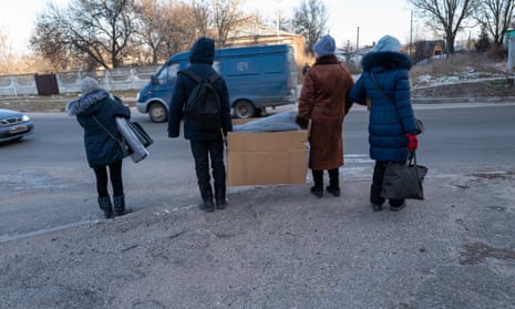 People receive aid in the heavily damaged town of Izium.