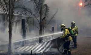 Firefighters work to save a house on Bullocky Way, Possum Brush, south of Taree on Tuesday.