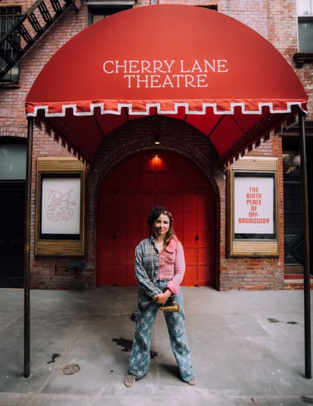 woman standing outside underneath theatre entryway