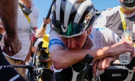 Tadej Pogacar slumps over the handlebars of his bicycle after losing considerable time on Jonas Vingegaard during a brutal stage for the Slovenian