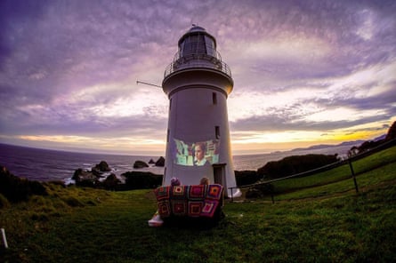 Hannah Sutton and her partner watch a film projected on to the lighthouse on Maatsuyker Island