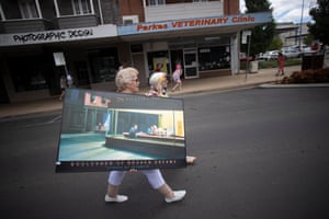 A woman carries Gottfried Helnwein’s Boulevard of Broken Dreams poster through the streets of Parkes