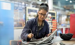 Female apprentice electrician in car factory