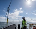 Worker looking out from ship to offshore wind farm