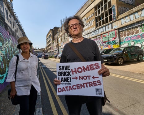 A man holds a 'Homes not Datacentres' sign on Brick Lane