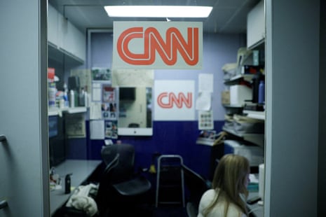 the CNN logo is posted on a small office room