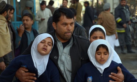 A man helps to evacuate schoolgirls from a school near the Pakistani consulate in Jalalabad.