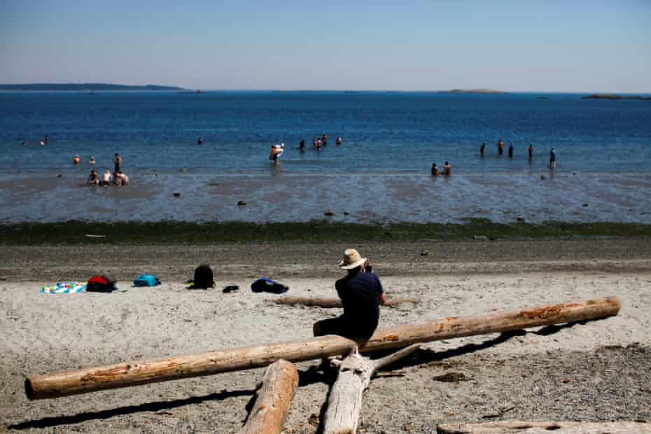 Orang-orang bersantai di Willow's Beach di Victoria, British Columbia.  Gelombang panas menyebar ke barat laut Amerika Serikat dan barat daya Kanada.