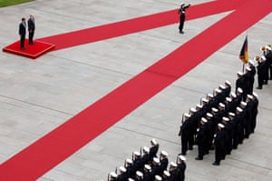 A red carpet bisects an area outside the the Chancellery in Berlin while Rishi Sunak and Olaf Scholz listen to their respective national anthems being played as part of a guard of honour in Berlin, Germany