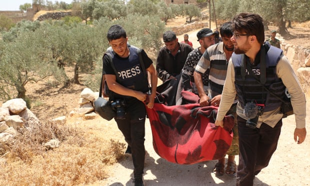 Members of the press carry a body of a victim pulled from the wreckage of a house after shelling by the forces of the Bashar al-Assad regime and its allies in Idlib province on 17 July.