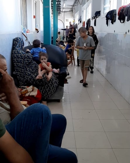 People shelter in what looks to be a hospital corridor