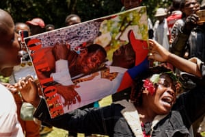 An anguished mourner holds a photo of Odinga