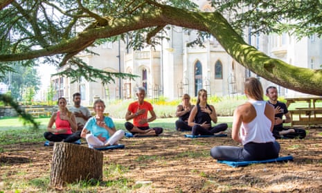 A yoga session under tree in stately home grounds