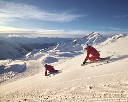 Two skiiers head down a slope
