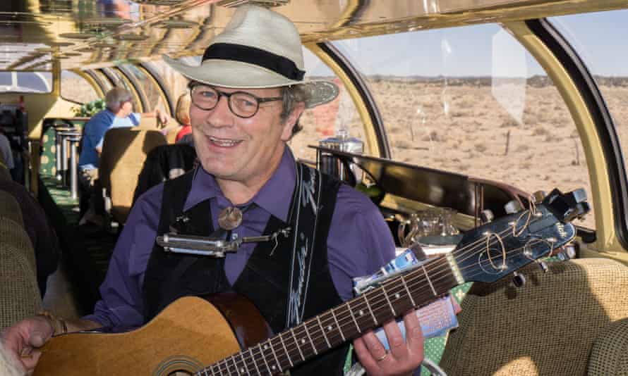 A musician strumming folk songs onboard the Williams to South Rim train.