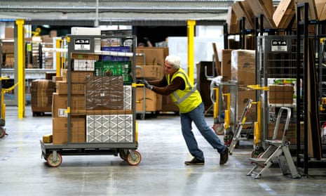 A worker moves merchandise at an Amazon fulfillment center 3 May 2018 in Aurora, Colorado. 