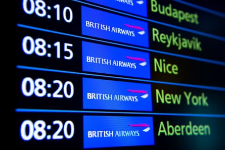 a BA flight display board shows flight departures to various destinations including New York