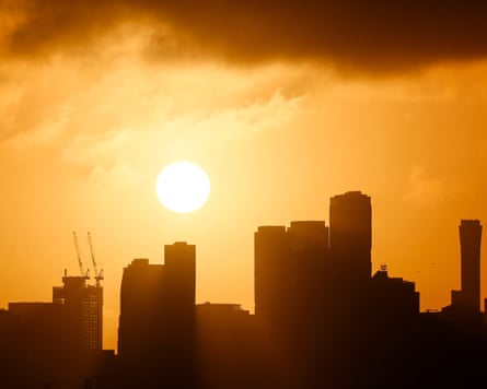The Melbourne skyline is silhouetted above the rising sun.