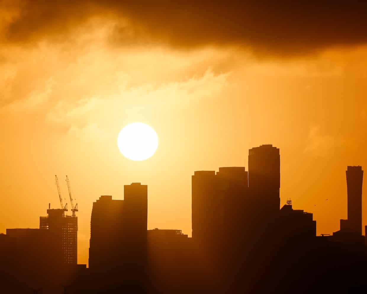 The Melbourne skyline is silhouetted above the rising sun.