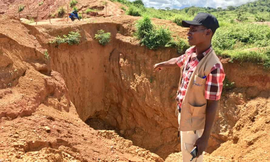 A field worker from local watchdog Foder points out the depth of an abandoned gold mine in eastern Cameroon
