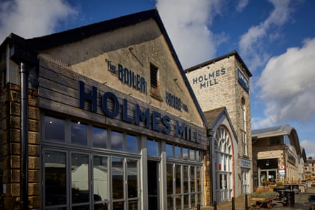 Stone buildings with multipaned windows and the lettering ‘Holmes Mill’.