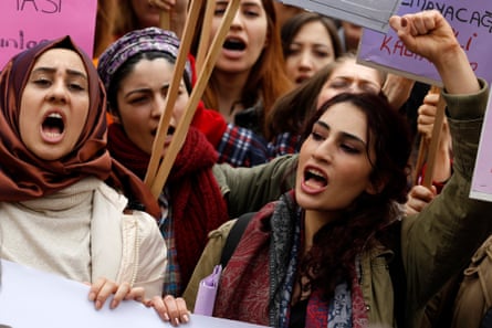 Women, including some in headscarves, raise their fists during a protest in Turkey in 2018.