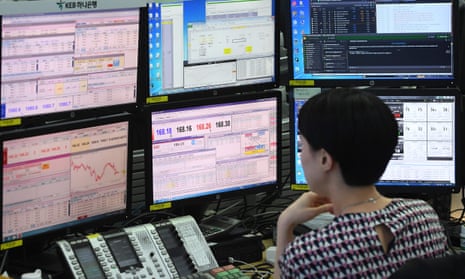 A currency dealer monitors exchange rates in a trading room at the KEB Hana Bank in Seoul.