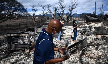 A resident looks for belongings through the ashes of their family’s home in Lahaina.