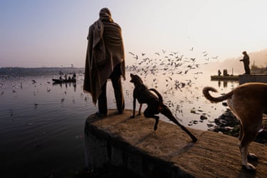 The Pause Before Light (Second place single winner)‘This photograph was taken on a cold morning by the banks of the Yamuna River in Delhi, India. The man was standing still, wrapped in a shawl, as if absorbing the stillness of the moment. A stray dog beside him, tense with instinct, sensed the frenzy of birds flying into the dawn sky. I did not ask them to pose. I simply observed, drawn to the contrast between movement and stillness, animal and human, darkness and awakening light’