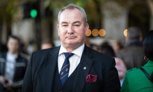 Mick Neville in a suit and tie in a busy street