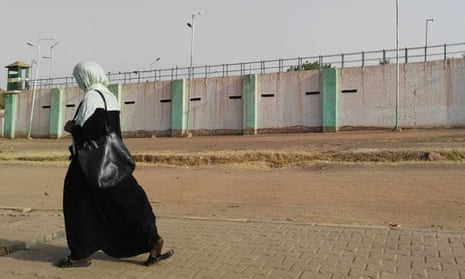 A Sudanese woman walks by the walls of Kobar prison where ousted president Omar al-Bashir is detained in Khartoum