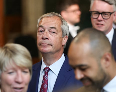 Farage walks through a crowd the House of Commons