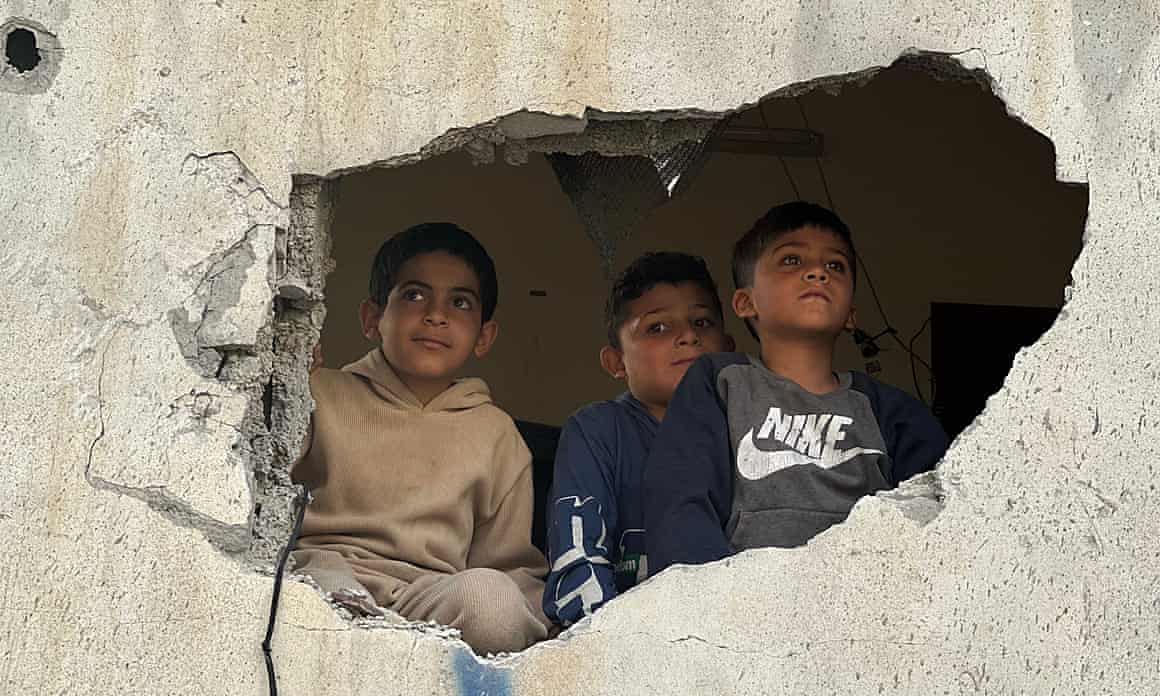 Children in Gaza look through a damaged building following an Israeli airstrike in Khan Younis on 22 April.