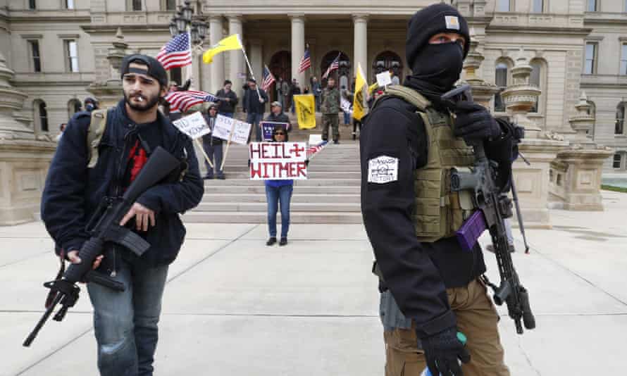 Men carry rifles near the steps of the state capitol building in Lansing, Michigan, in April 2020 during a protest over Governor Gretchen Whitmer's orders to keep people at home and businesses locked during the coronavirus outbreak.