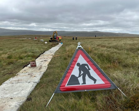 Laying stones on a path across boggy ground