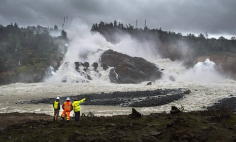 A member of Cal Fire, right, talks to workers on the Oroville Dam project in front of the main spillway in Oroville, California, fears for which forced the evaucation of 200,000 people in February.