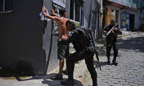 A member of the Brazilian military police frisks a suspect during a large-scale operation against drug trafficking and militias in the Morro do Banco favela in Rio de Janeiro.
