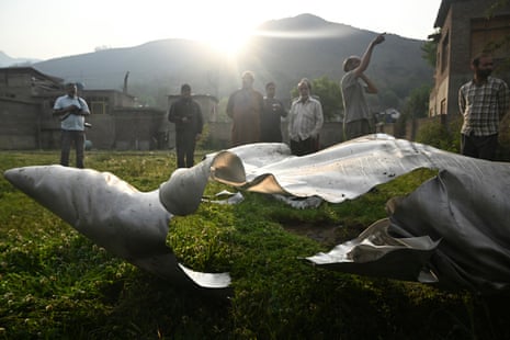 People look at a part of an aircraft in Wuyan near Indian-administered Kashmir's main city of Srinagar.