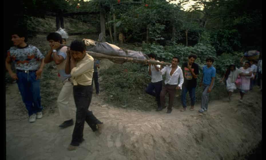 Relatives of 15 family members massacred by civil war combatants, bearing bodies on stretchers.