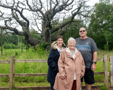 Three people stood in front of the trees