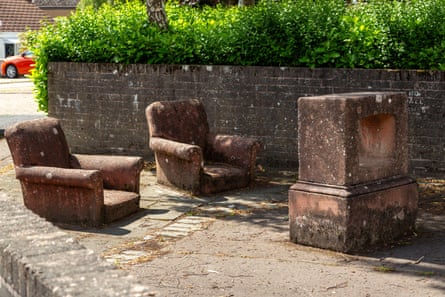 Street sculpture of two armchairs in front of empty television