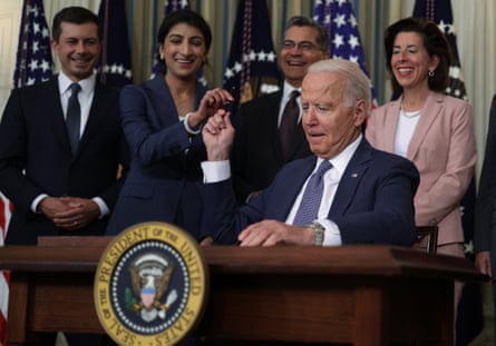 Joe Biden hands a signing pen to Lina Khan on 9 July after signing an executive order to promote competition in the American economy.