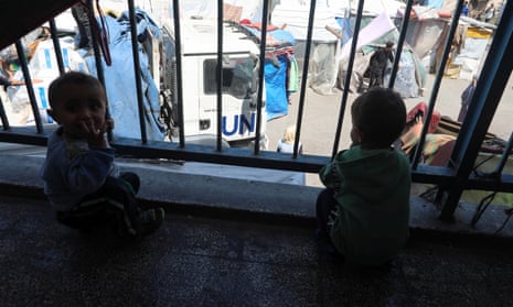 Palestinian children look on as aid is distributed at a shelter centre in Deir Al-Balah, in the central Gaza Strip.