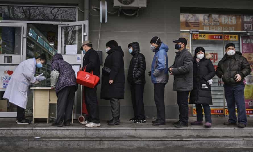 Chinese residents line up to get a free protective mask at a local pharmacy in Beijing.