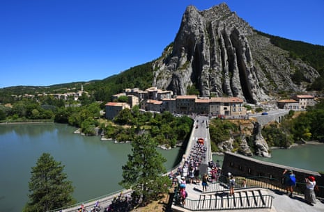 The peloton pass by an impressive rock formation prior to the start of Stage 8.