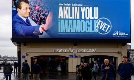 Pedestrians walk past an electoral poster for Ekrem Imamoglu in Istanbul.