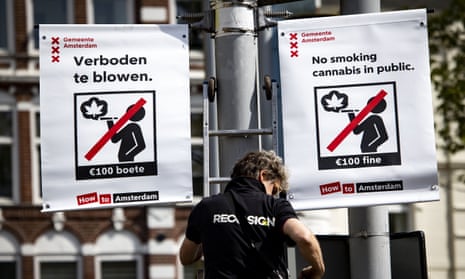 A worker hangs a sign in the Nieuwmarkt publicising the new ban.